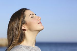 Woman portrait breathing deep fresh air on the beach