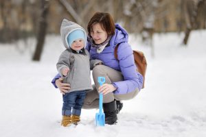 Beautiful middle aged woman and her adorable little grandson at the winter park