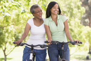 Two women on bikes outdoors smiling