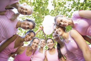 Smiling women in pink for breast cancer awareness